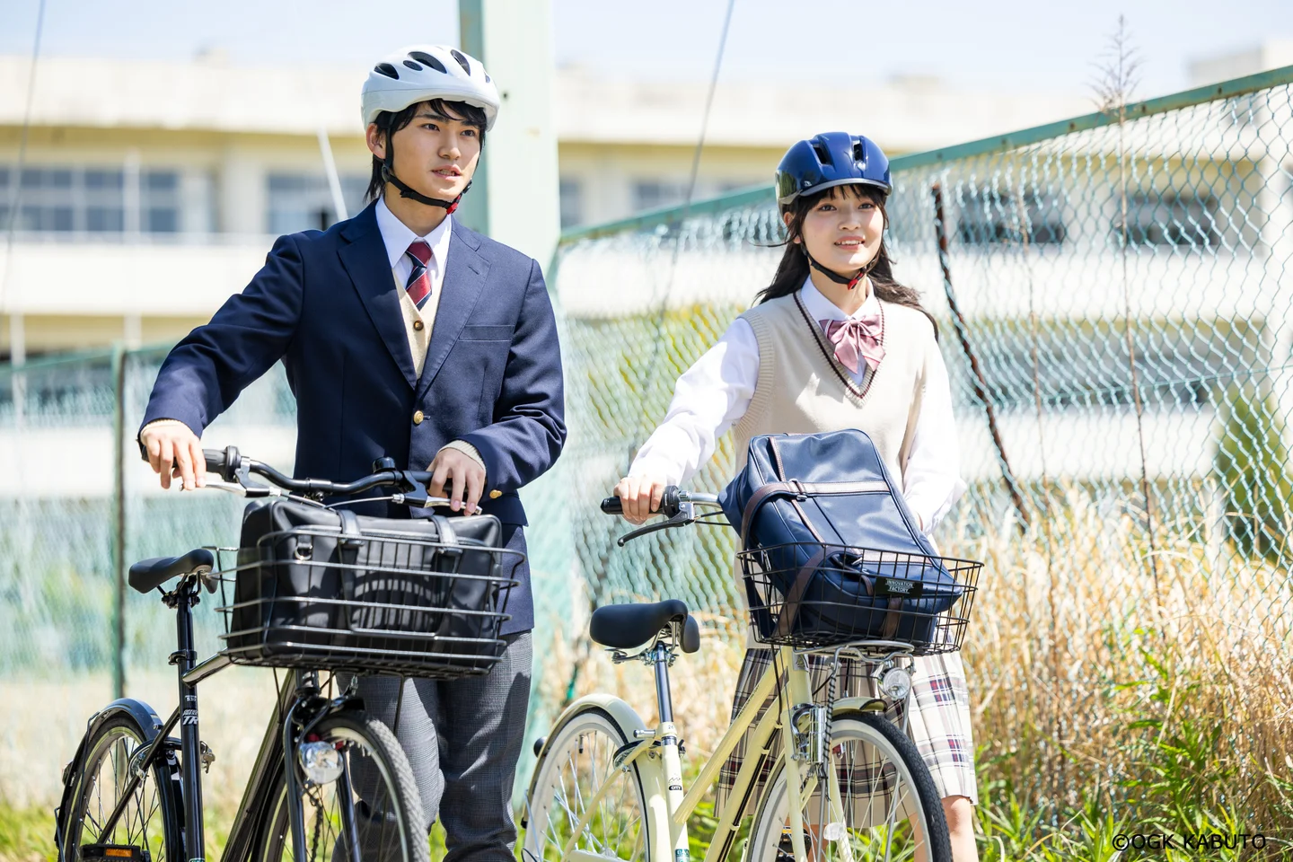 高校生が自転車に乗ってヘルメットを着用している様子